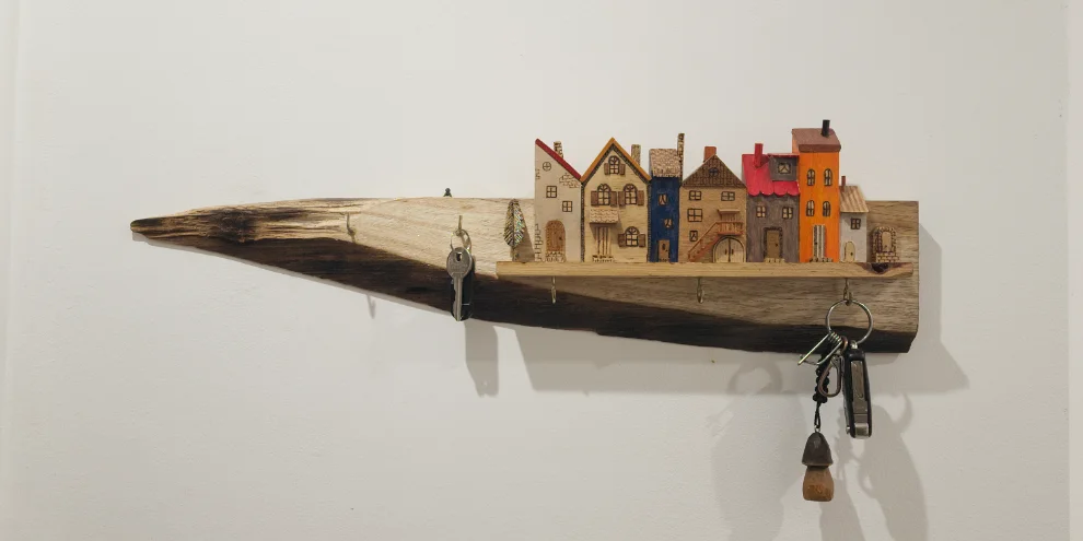 Wall-mounted key holder: a live-edge reclaimed board topped with hand-carved painted miniature houses and five metal hooks